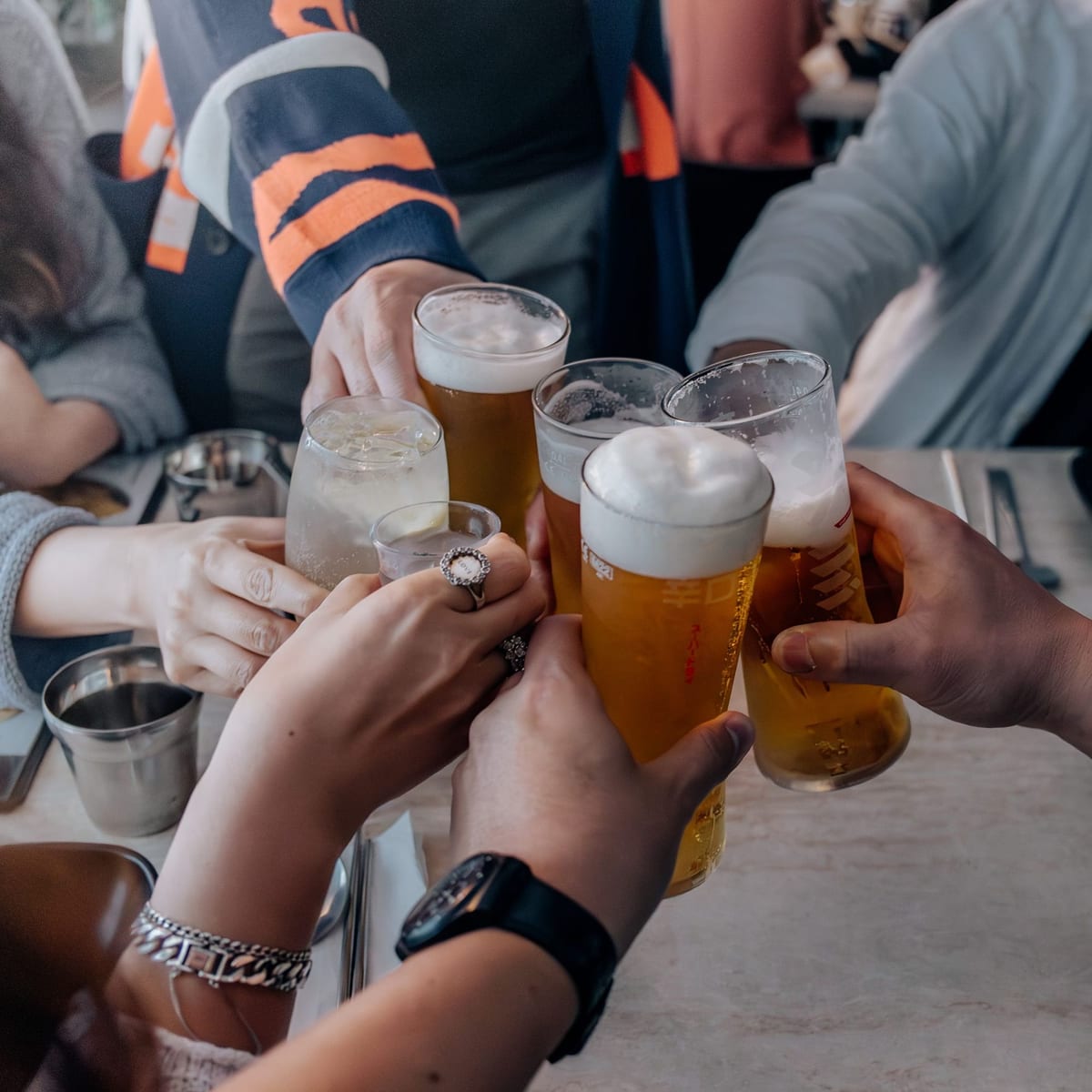 Hands raising glasses of beer for a toast