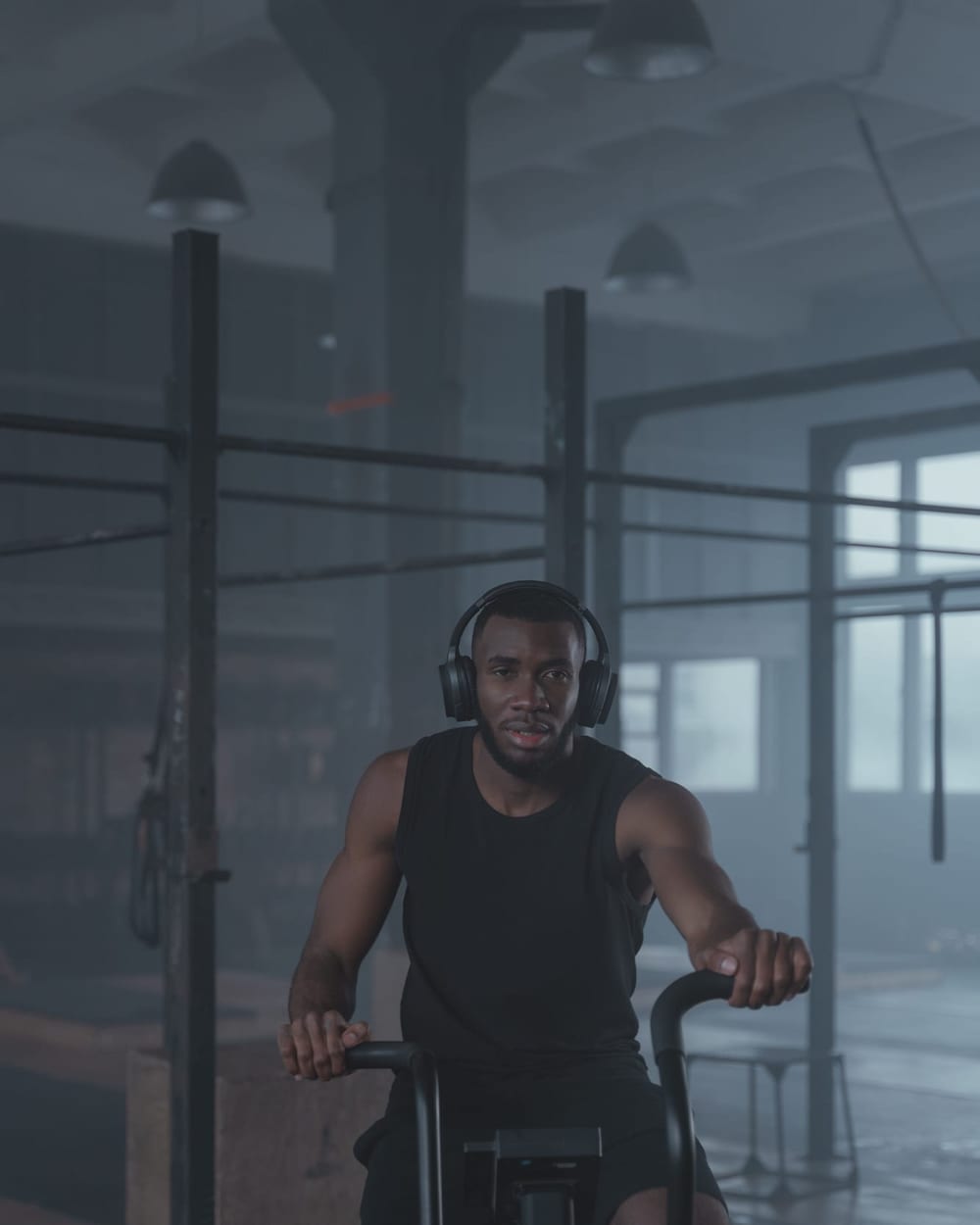 Man cycling on an air bike while wearing headphones