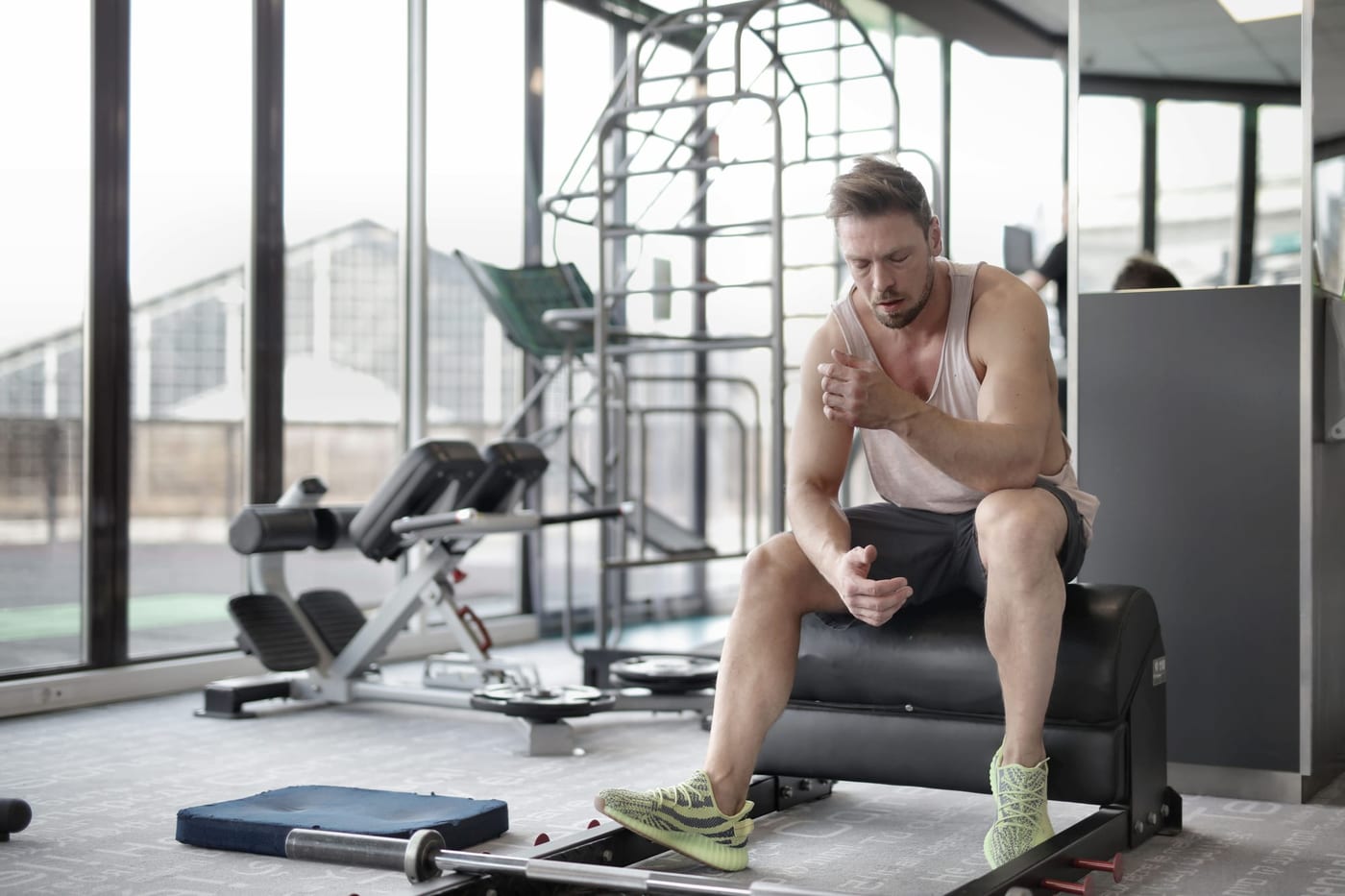 Man sitting on a gym bench catching his breath