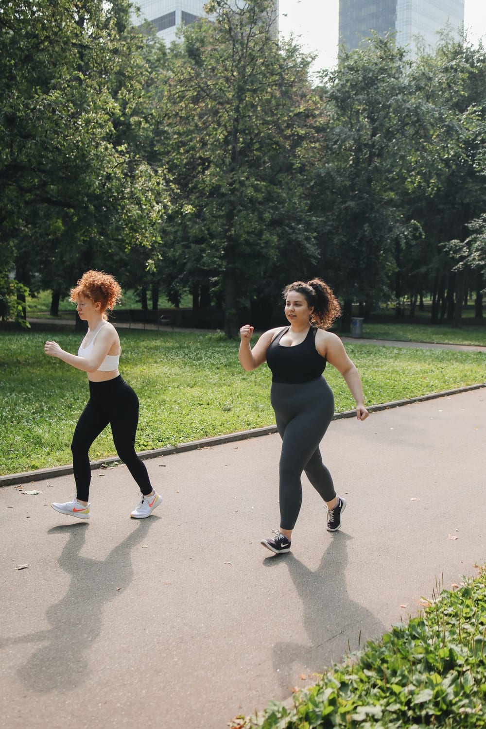 Two women walking briskly through a park