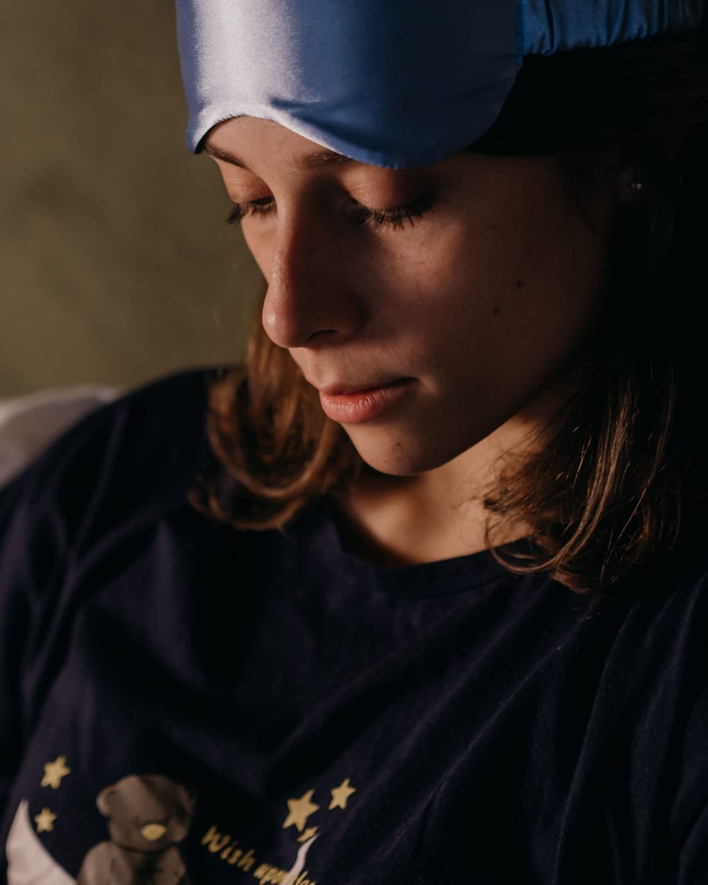 Woman with a blue sleep mask pushed up on her forehead