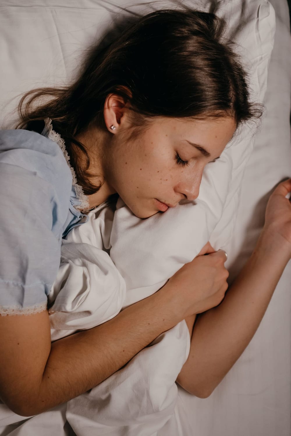 Young woman sleeping on a white pillow
