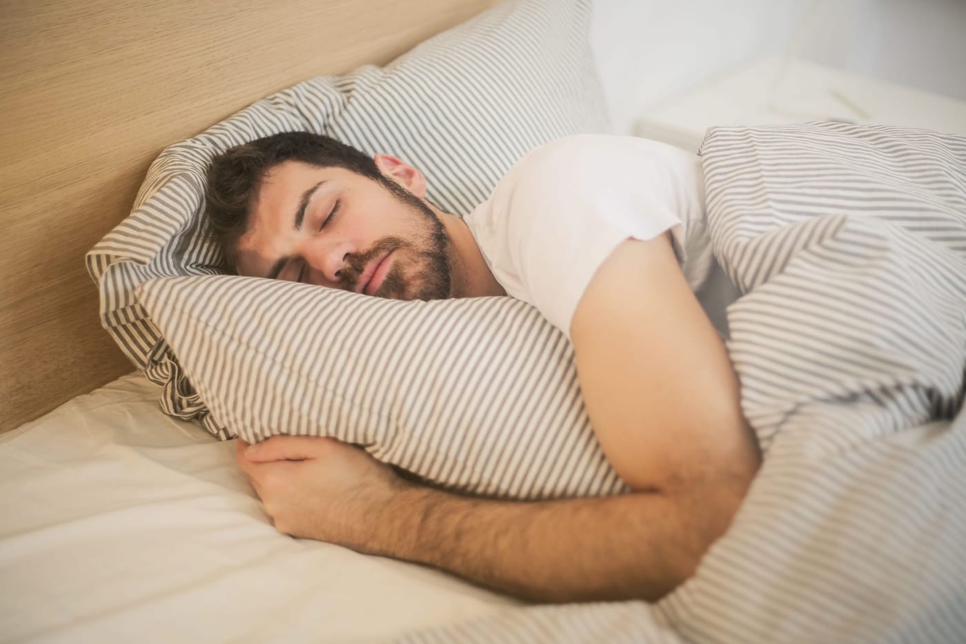 Man sleeping peacefully on a striped pillow