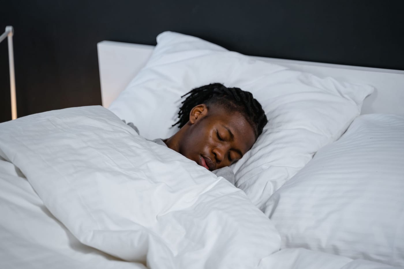 Person sleeping in a white bed