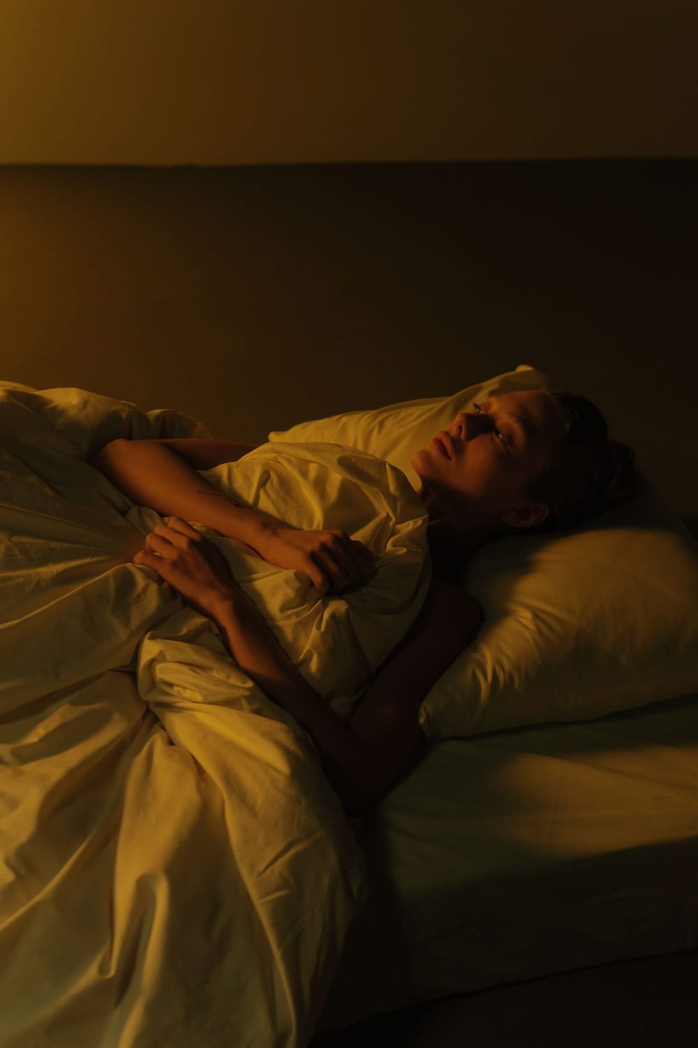 Person resting in bed in warm evening light